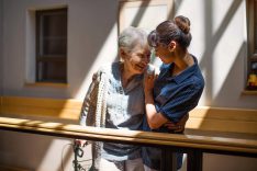 A healthcare worker embracing a happy senior woman