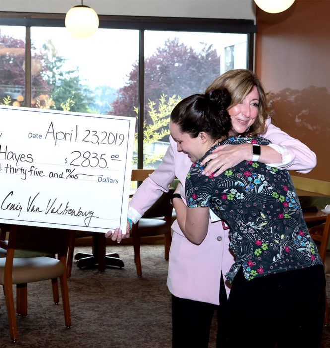 A jumbo check from the Blue Heron Foundation being given to a Willamette View healthcare worker.