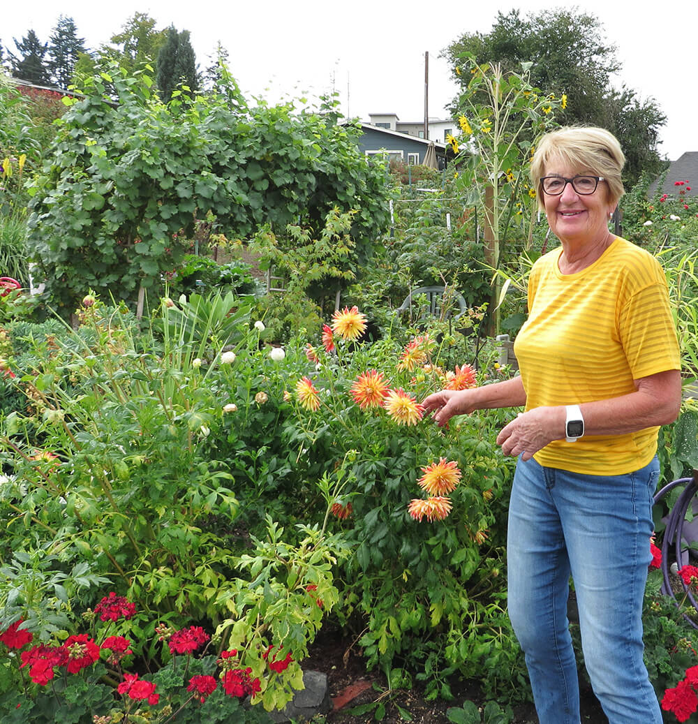 A woman enjoying the flowers in a garden at Willamette View
