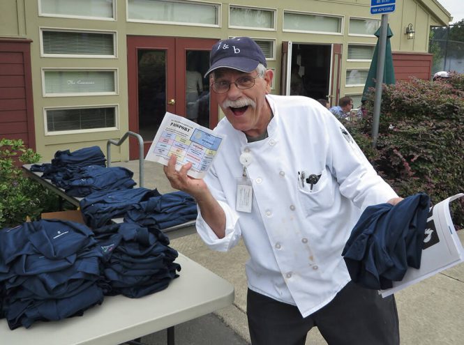 Employee holding up a passport card and a new staff shirt