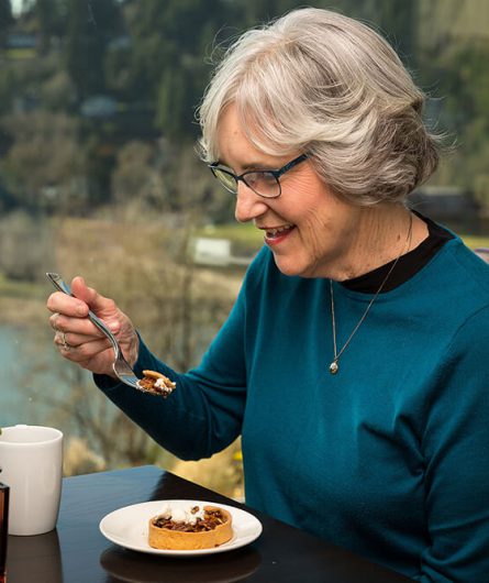 Woman eating a pecan tart with her coffee