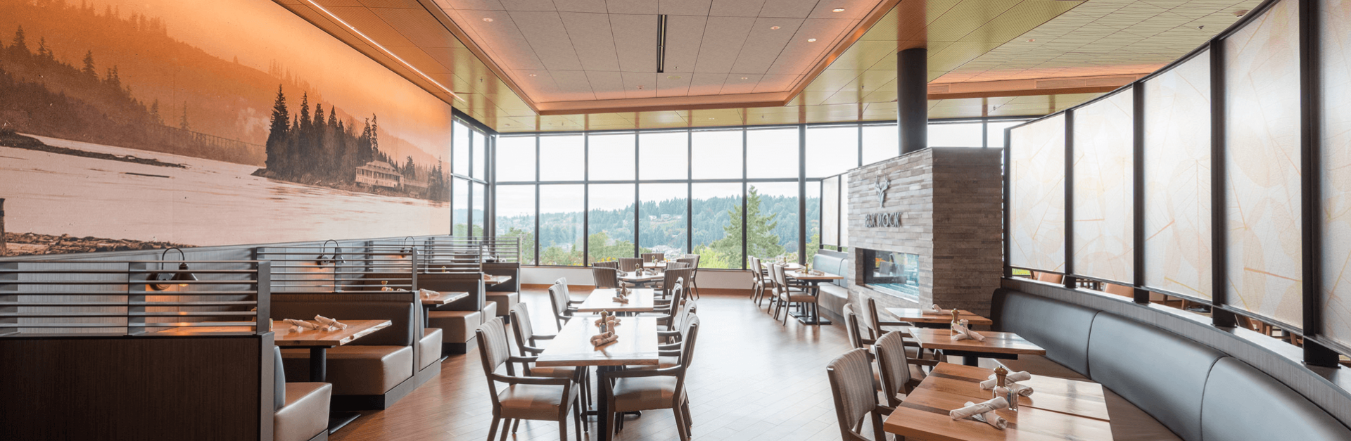 Elk Rock dining room with tall windows and a historic mural of the Willamette River