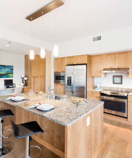 A Balcony Home kitchen with a large island and an office area in the background