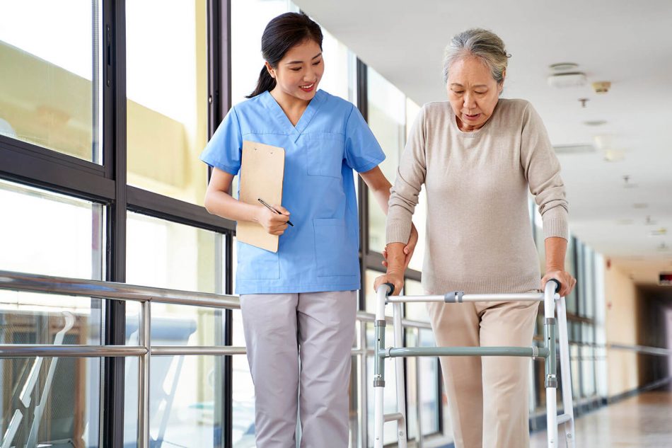 A healthcare worker assisting a woman with a walker