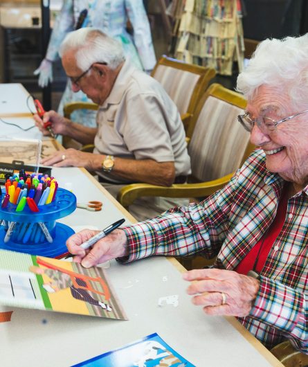 An art class were residents are drawing, painting and wood burning on wood panels