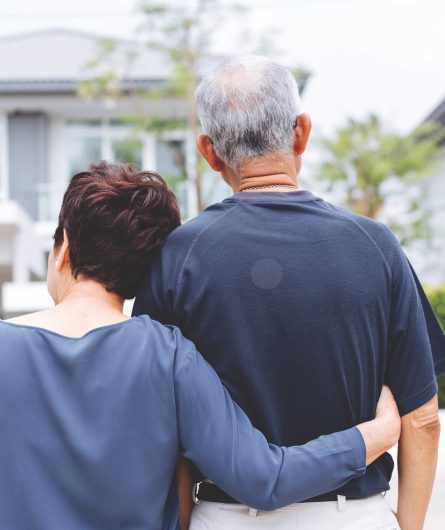 A couple looking back at their house from the street