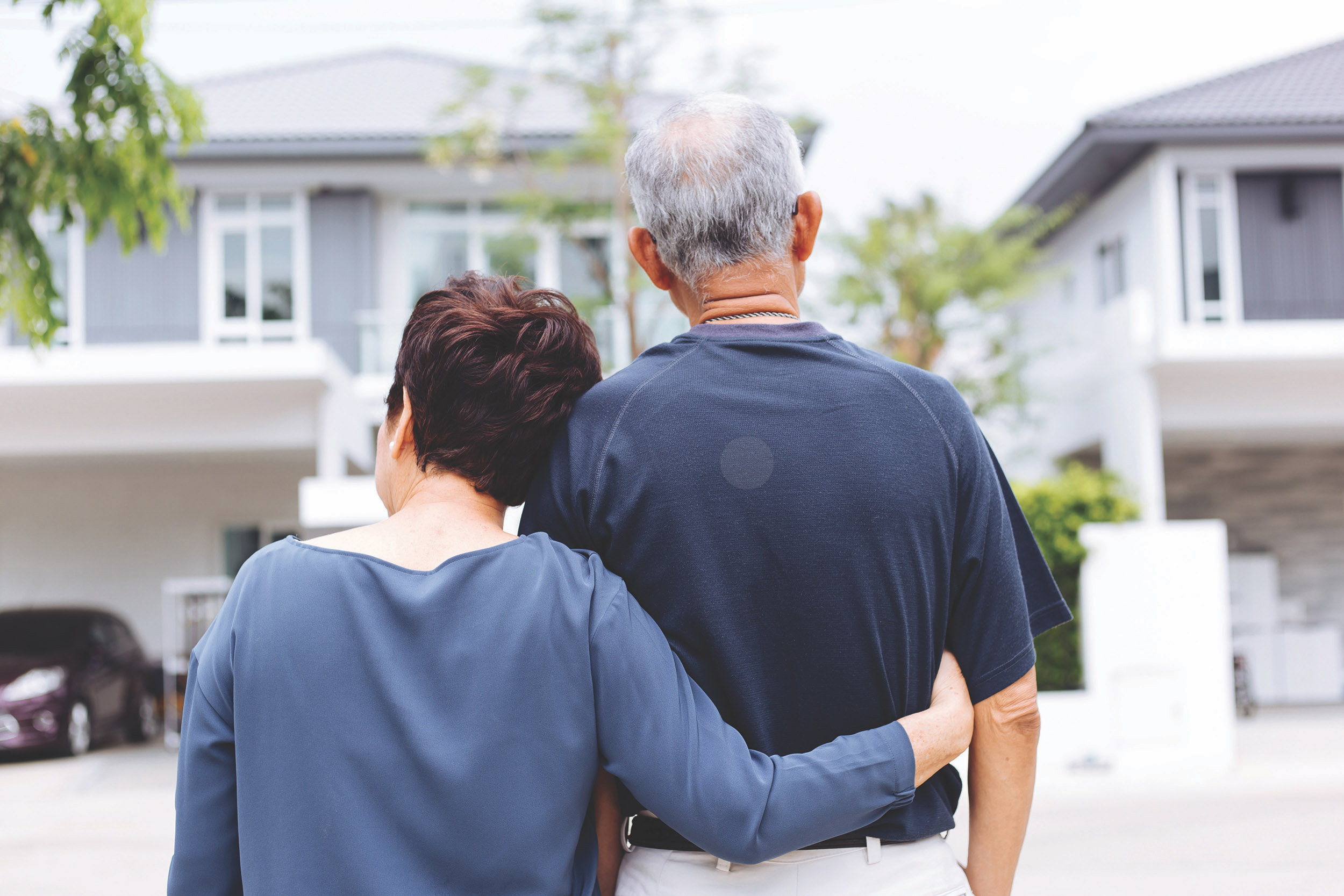 A couple looking back at their house from the street